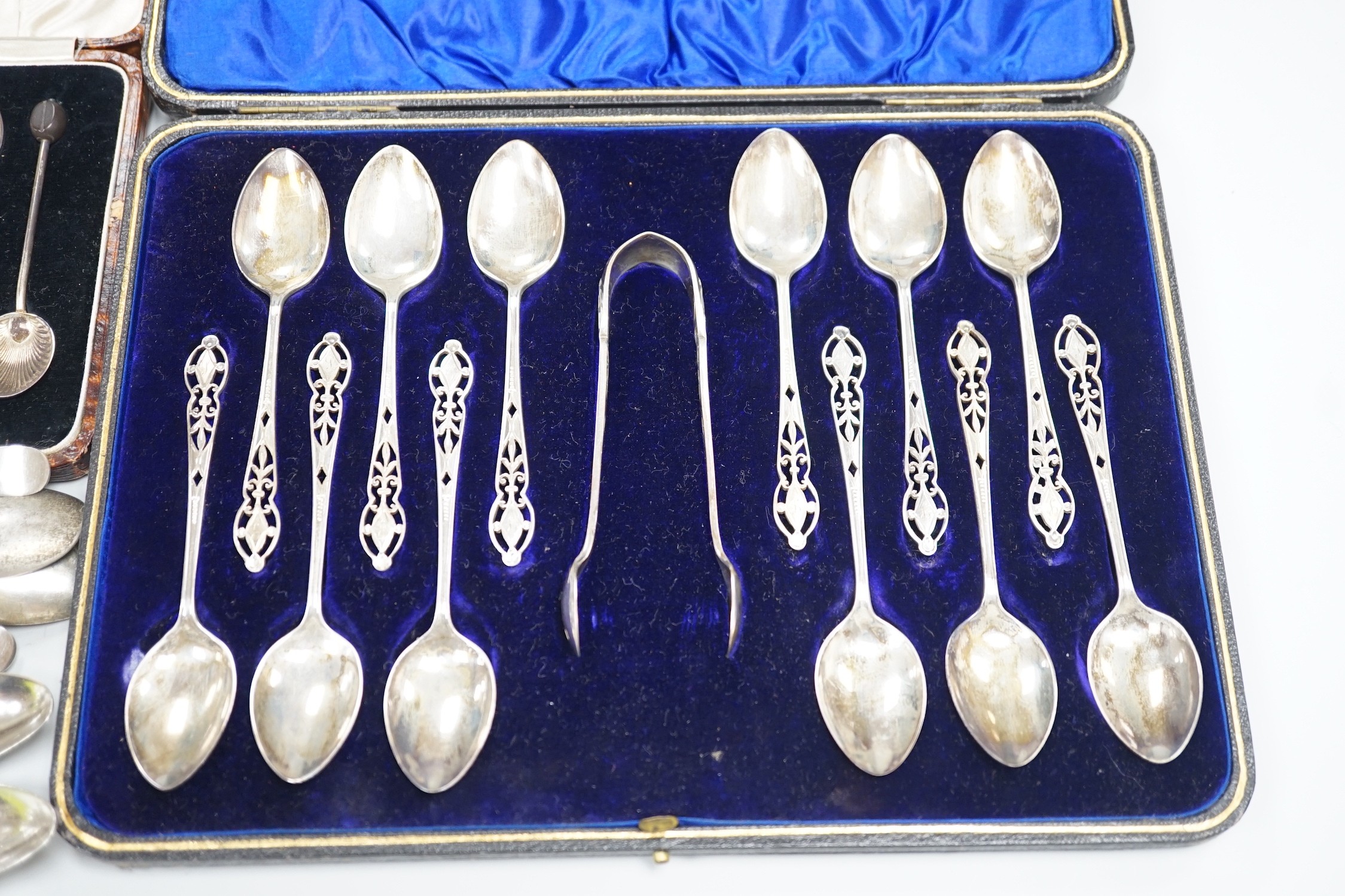 A cased set of twelve George V pierced silver teaspoons, with tongs, Sheffield, 1910, one other cased set of six silver bean end coffee spoons and eleven assorted mainly 19th century silver teaspoons.